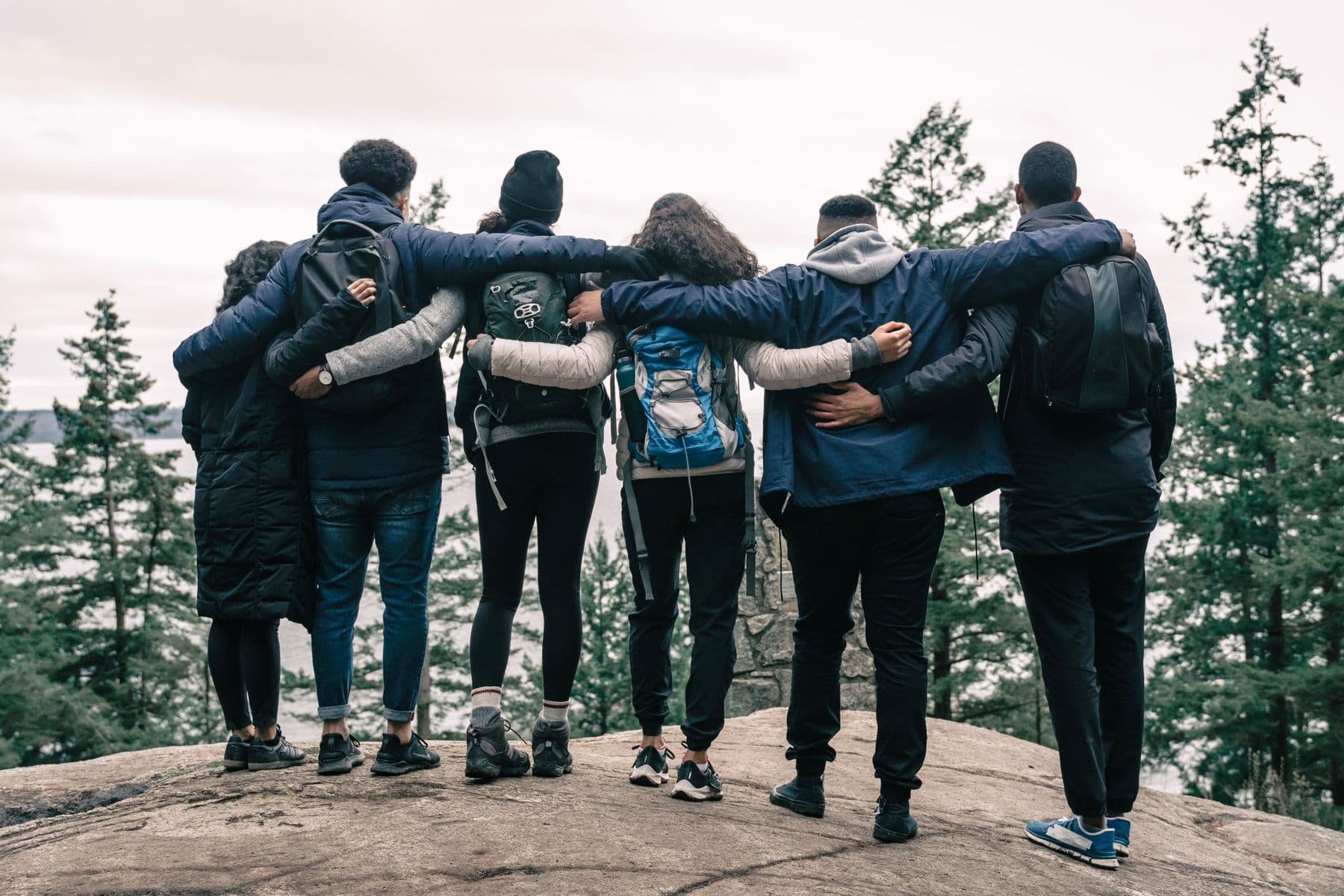 A diverse group of people supporting one another during an outdoor community experience