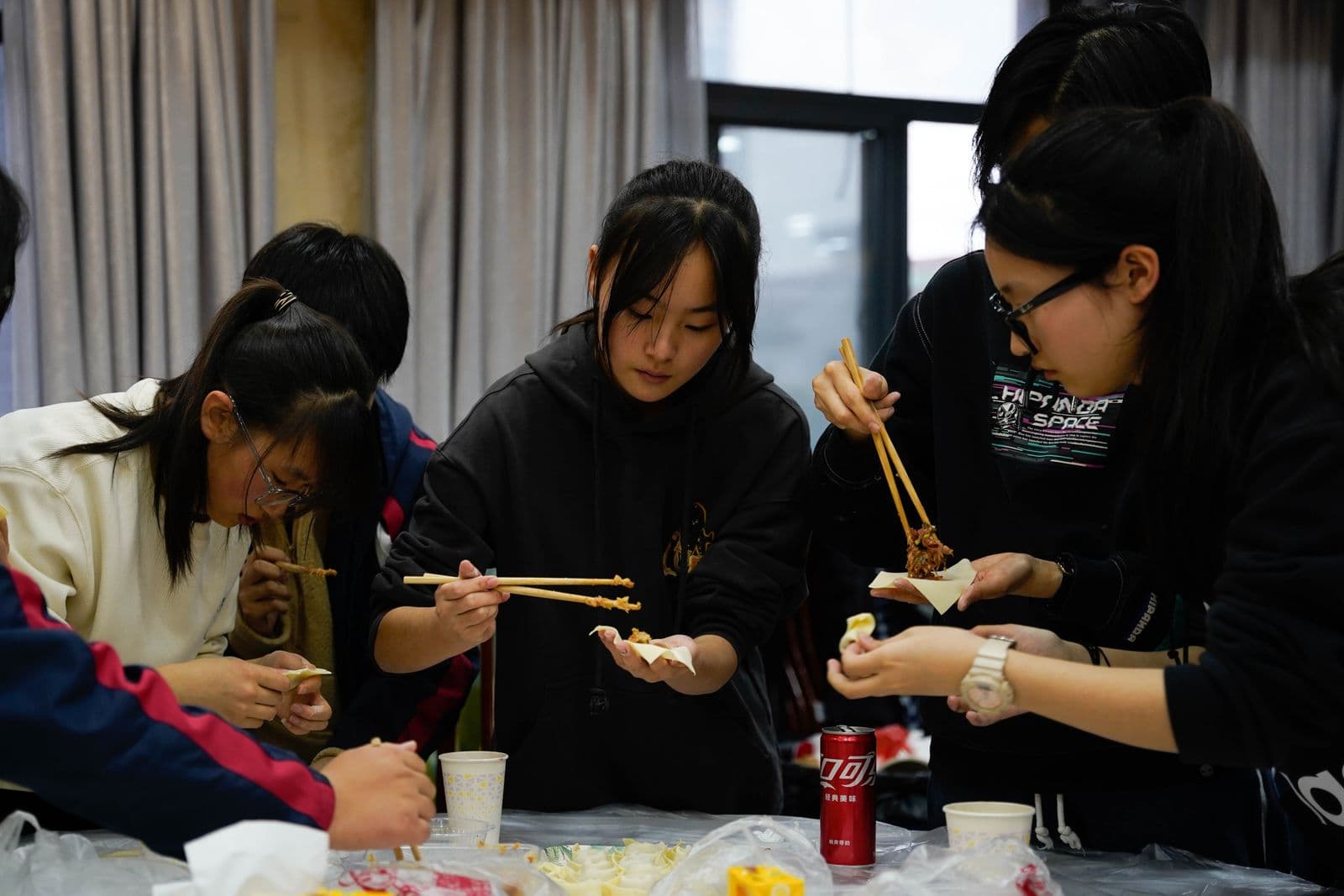 A group of young adults preparing food together during an interactive cooking activity