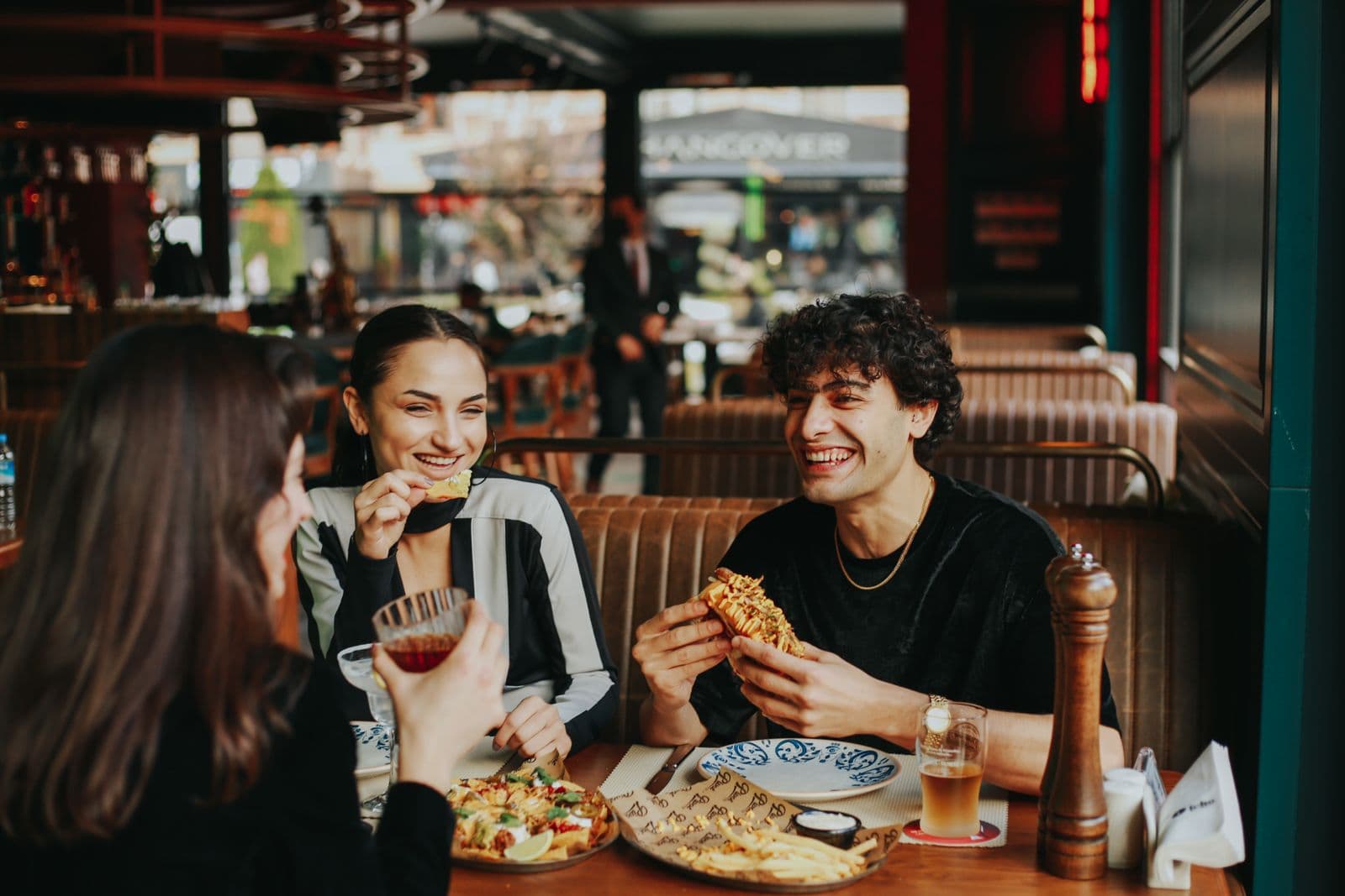 A group of friends eating out, laughing, and socializing at a restaurant