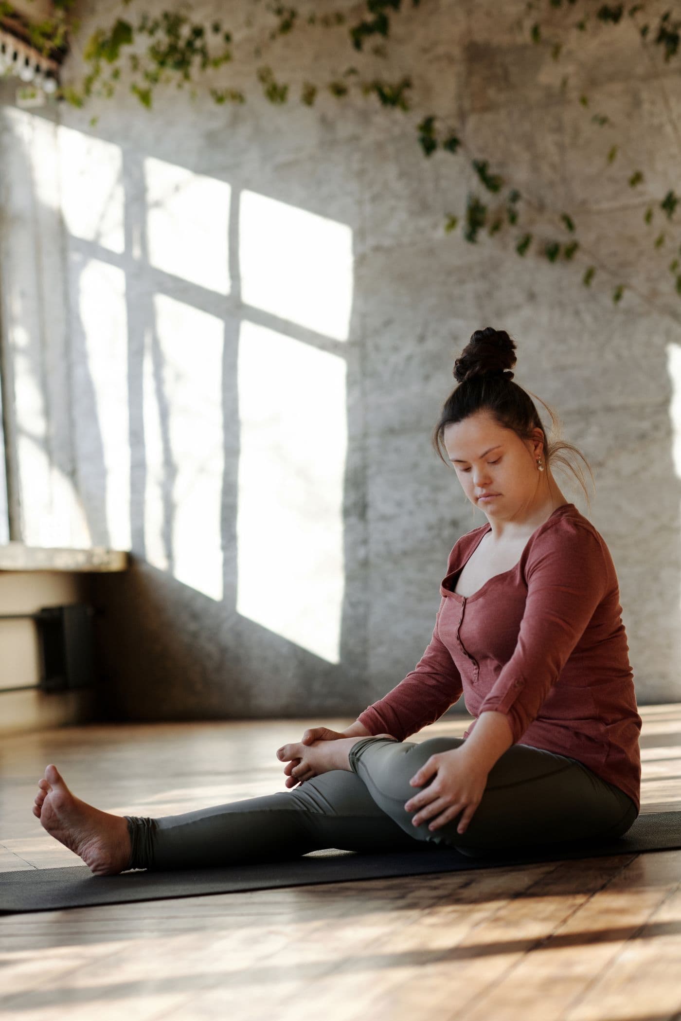 A young woman with Down syndrome participating in an adaptive yoga and wellness activity