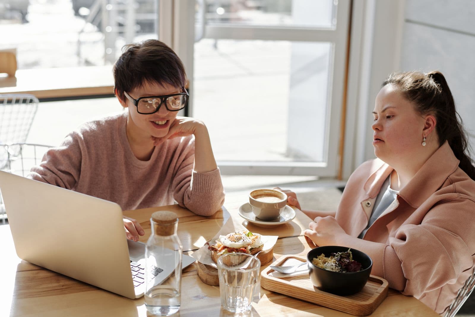 A young woman with Down syndrome connecting with a community partner over lunch
